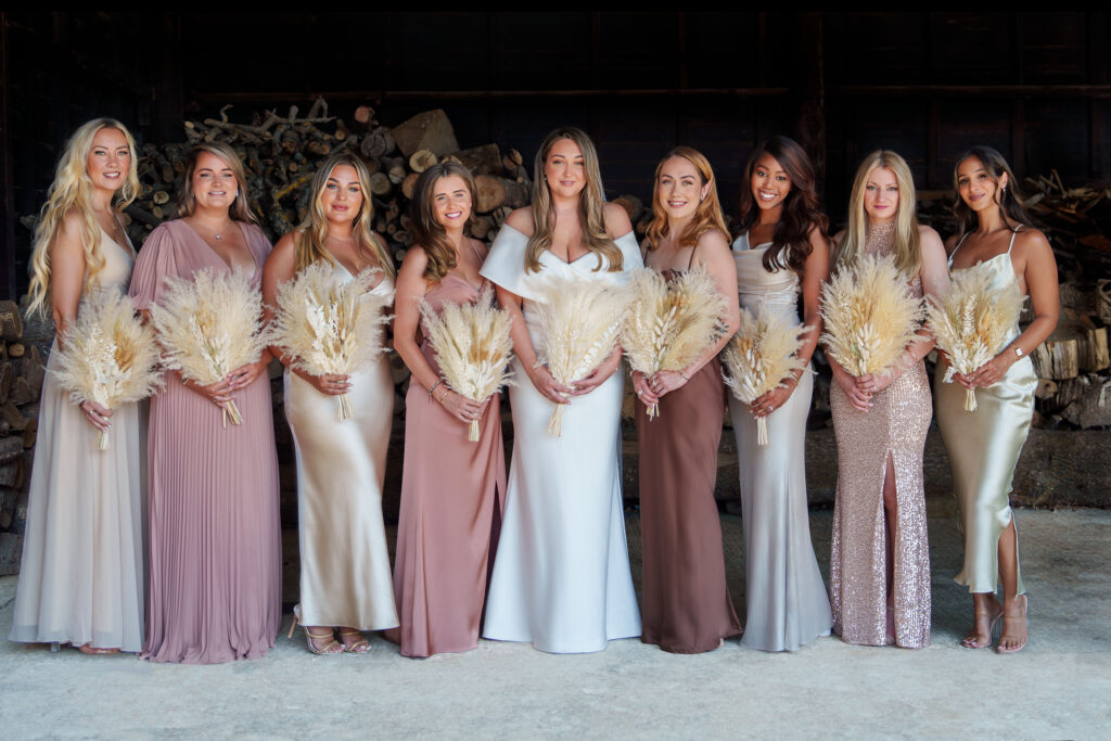 Bride with Eight Bridesmaids at Oak Barn, Frame Farm, Kent in elegant dresses by Kent wedding photographer.